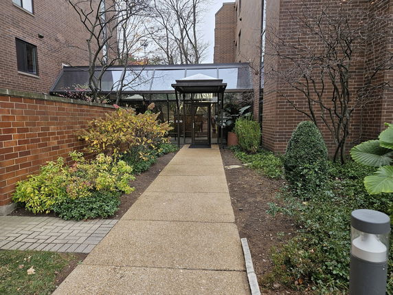 Front view of a building entrance with glass and brick walls.