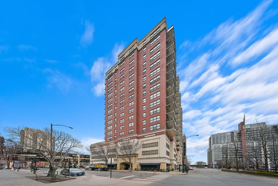 Front view of a tall residential building with red and beige facade.
