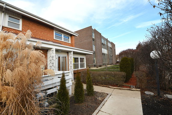 Front view of a two-story brick house with a porch.