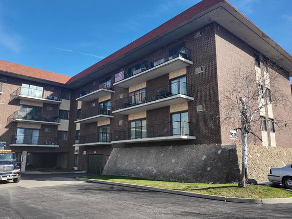Front view of a multi-story apartment building with balconies.
