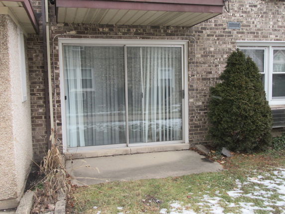 Rear elevation of a house with sliding glass doors and brick exterior.