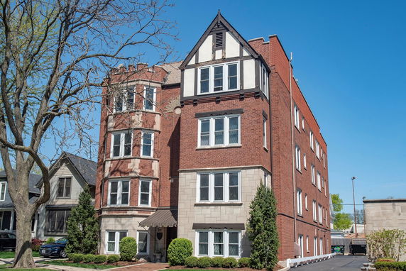 Front view of a multi-story red brick apartment building.