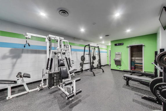 Gym area with exercise equipment and weightlifting machines.