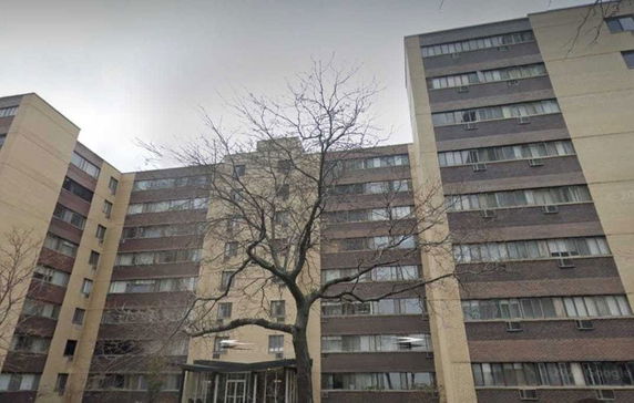 Front view of a multi-story residential building with large windows.
