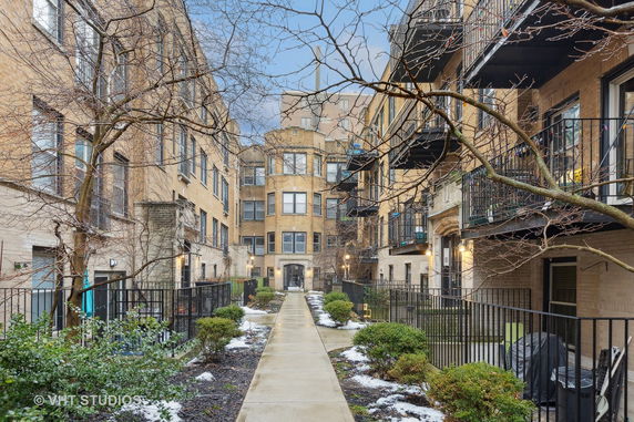 Front view of a multi-story apartment building with balconies.