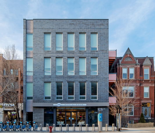 Front view of a multi-story commercial building with large windows.