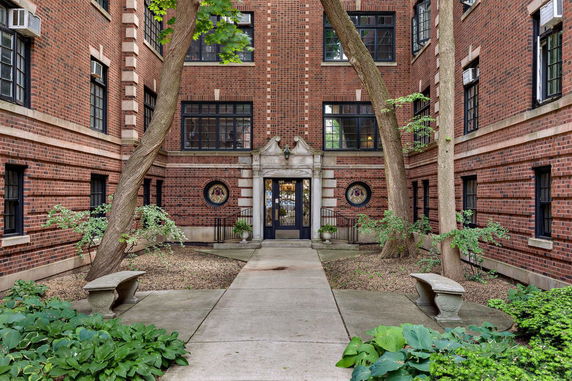 Front view of a brick apartment building with decorative entrance.