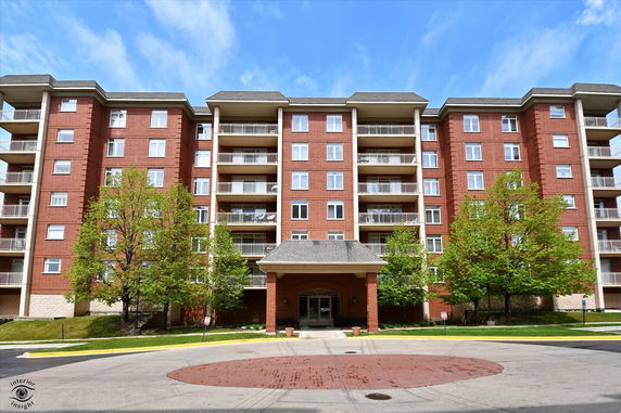 Front view of a multi-story residential building with brick facade and balconies.