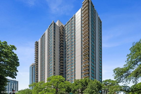 Front view of a tall apartment building with multiple balconies.