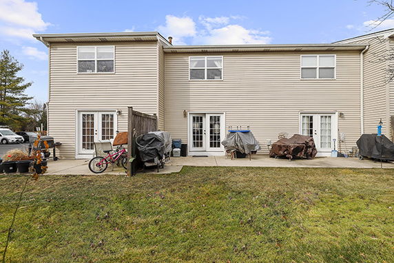 Rear view of a two-story house with a patio area.