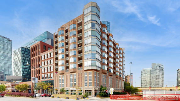 View of a multi-story residential building with a brick facade and large glass windows