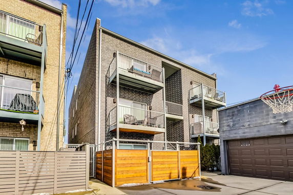 Front view of a multi-story apartment building with balconies.