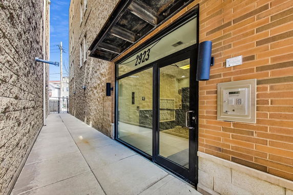 Entrance to a building with a glass door and keypad access.