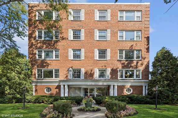 Front view of a multi-story brick building with numerous windows and a central entrance.