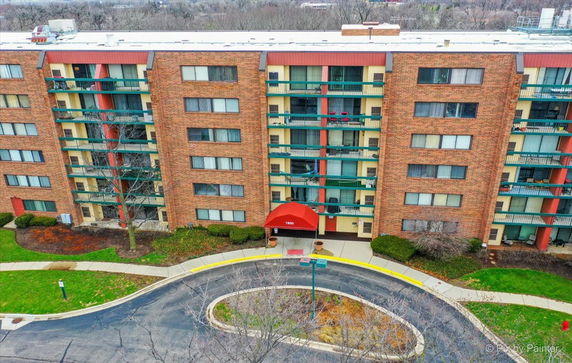 Front view of a multi-story apartment building with a red canopy entrance.