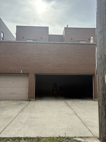 Front view of a brick building with a large garage door and a closed garage.
