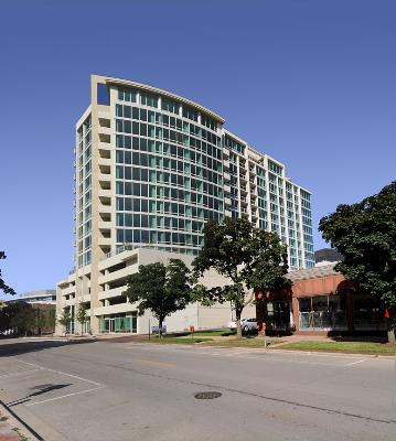 Front view of a multi-story modern building with large glass windows.
