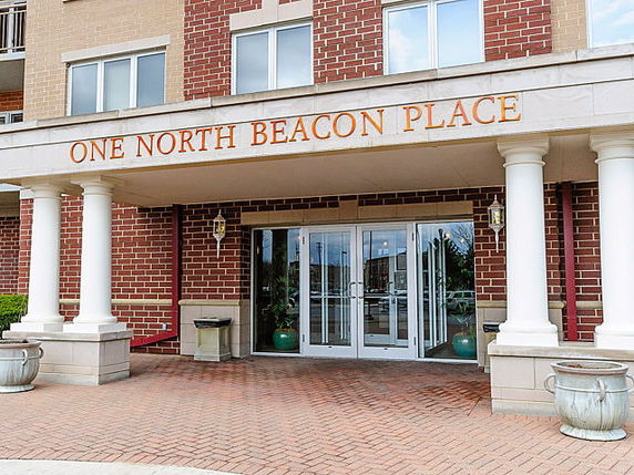 Front view of a building entrance with the name 'One North Beacon Place' displayed above the doors.
