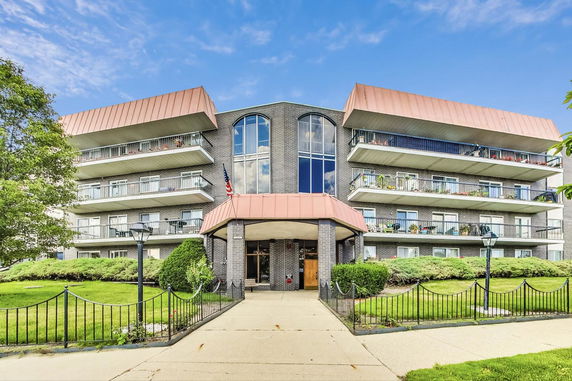 Front view of a multi-story building with balconies and a decorative entrance.