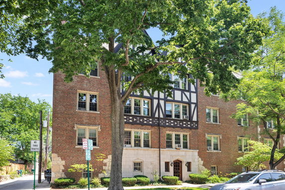 Front view of a multi-story brick building with Tudor-style facade elements.