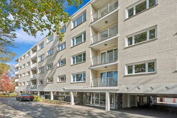 Front view of a multi-story apartment building with balconies.
