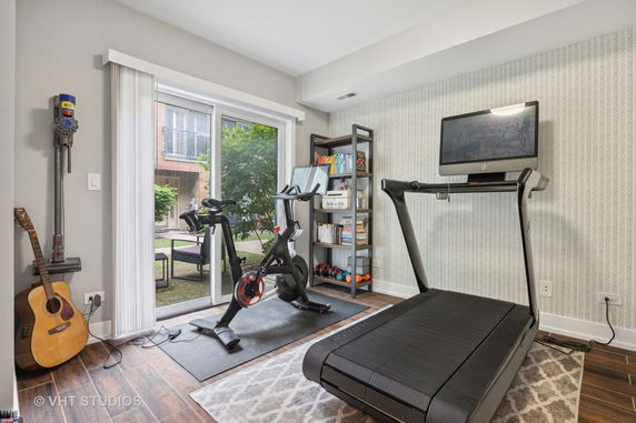 Indoor home gym with exercise equipment and a large window.