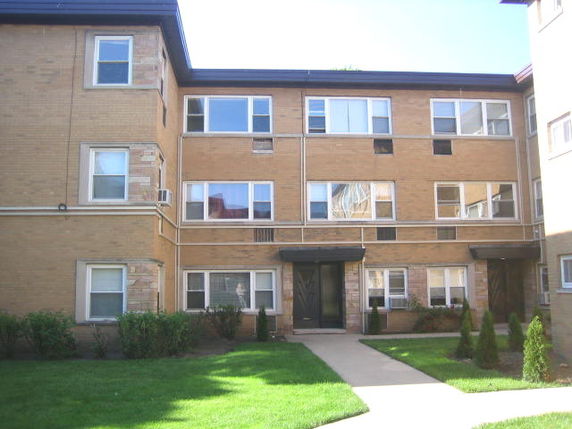 Front view of a three-story apartment building with brick exterior.