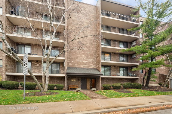 Front view of a multi-story apartment building with balconies.