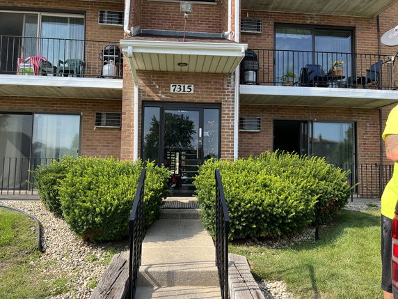 Front view of a multi-story brick building with balconies.