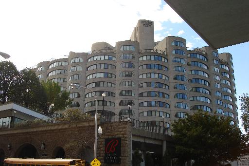 Front view of a multi-story building with numerous windows and a curved architectural design.