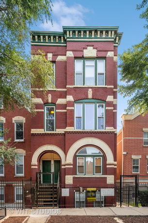 Front view of a multi-story brick building with decorative architectural elements.