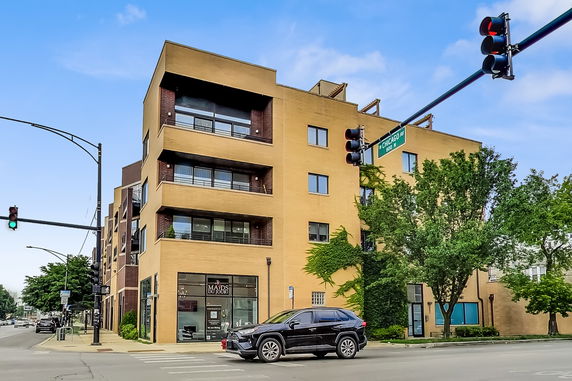 Front view of a multi-story building at an intersection in an urban area.