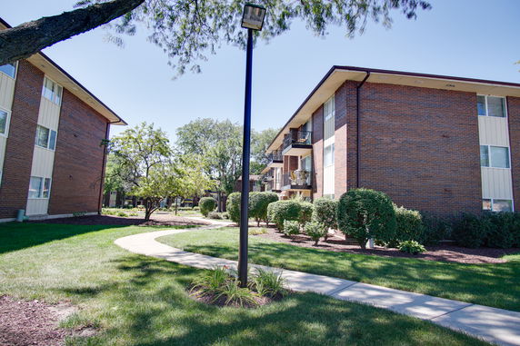 Front view of a multi-story apartment building with brick exterior and balconies.