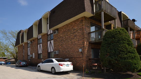 Front view of a multi-story brick building with balconies.