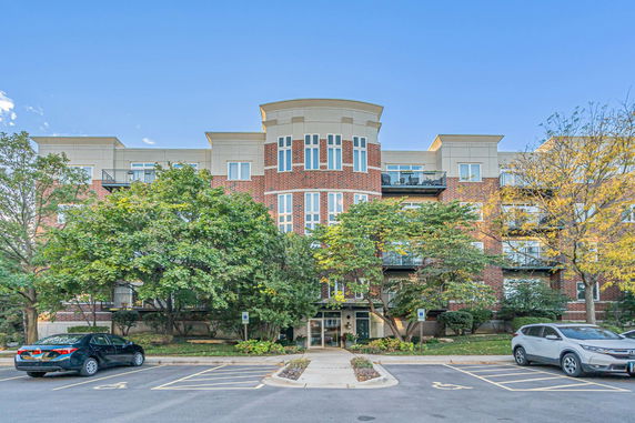 Front view of a multi-story brick building with large windows and balconies.