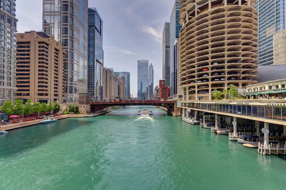 View of a city skyline with a river running through it, surrounded by tall buildings.