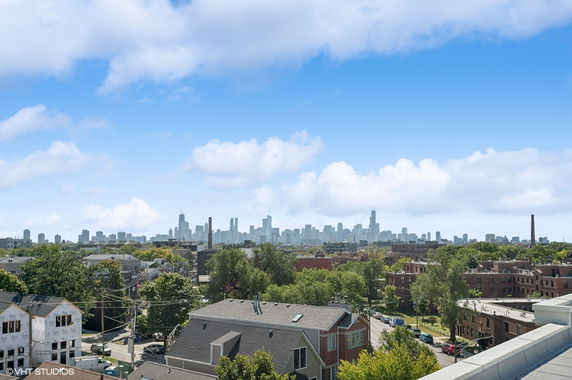 Panoramic view of a city skyline from a rooftop.