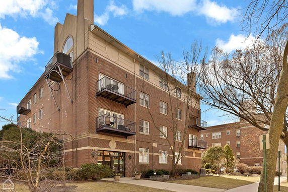 Front view of a multi-story brick building with balconies.