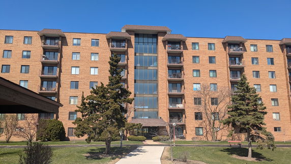 Front view of a multi-story apartment building with balconies.