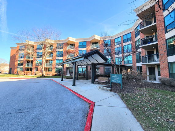Front view of a multi-story residential building with balconies and large windows.