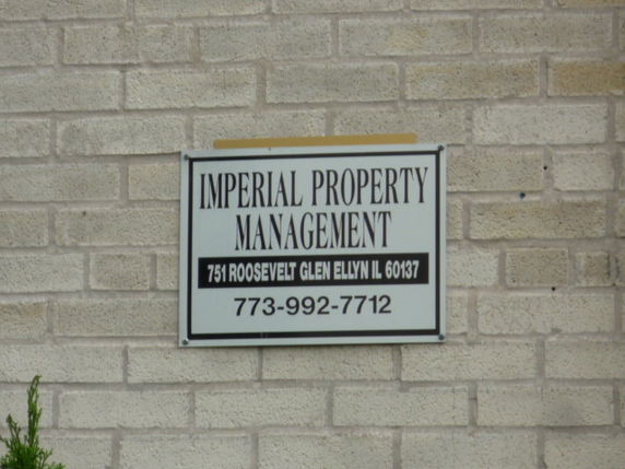 Exterior wall with a property management sign.