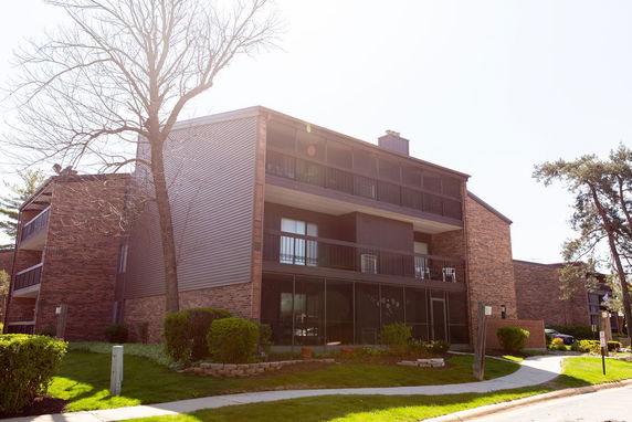 Front view of a multi-story brick apartment building with balconies.