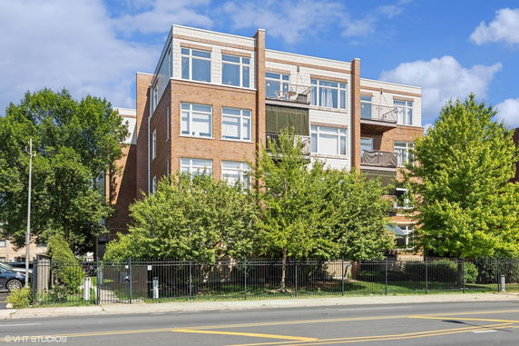 Front view of a multi-story building with balconies and large windows.