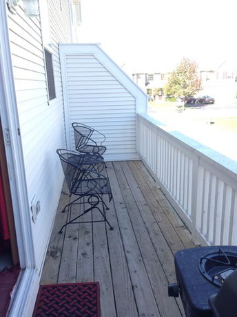 Rooftop patio with chairs and a railing.