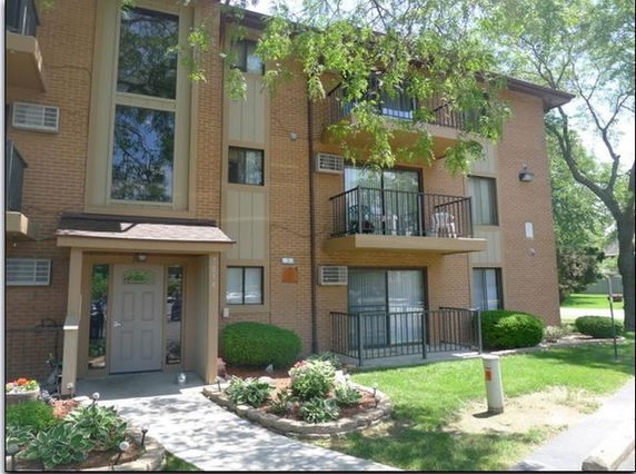 Front view of a multi-story residential building with balconies.