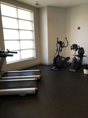 Interior view of a fitness room with exercise equipment such as treadmills and elliptical machines.
