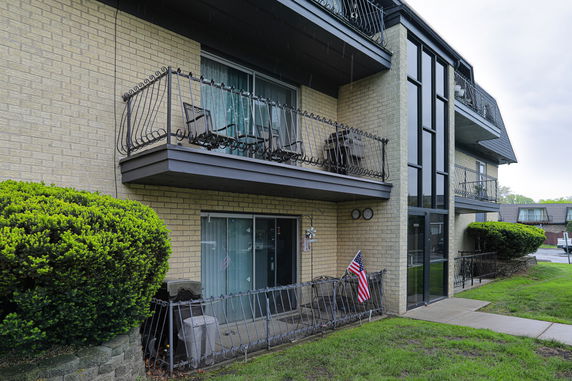 Front view of a multi-story brick building with balconies.