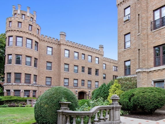 Front view of a multi-story brick building with castle-like features.
