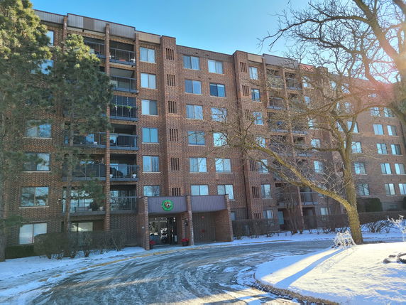 Front view of a multi-story brick building with balconies.