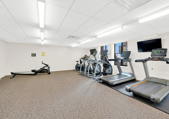 Indoor gym area with exercise machines and treadmills.